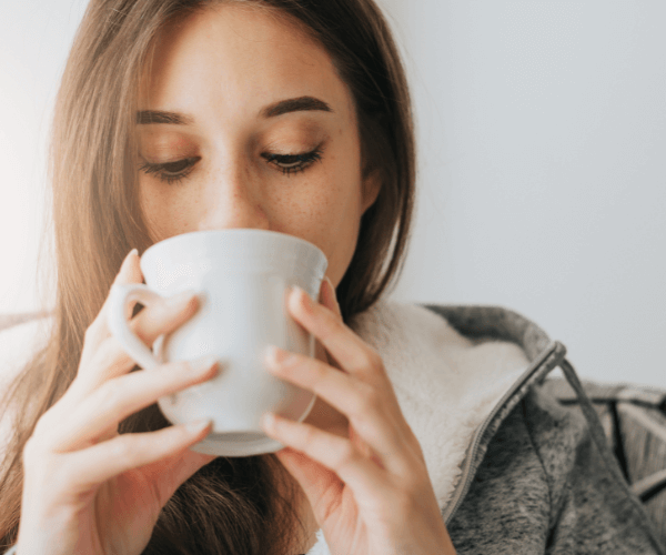 Woman Sipping Tea from White Mug