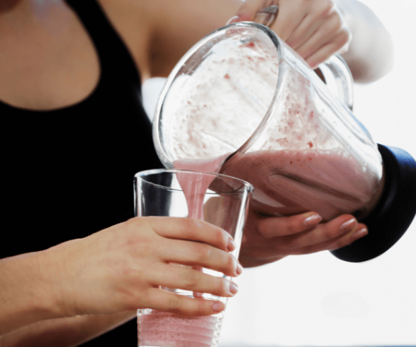 Woman pouring protein shake